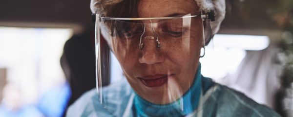 Une femme âgée avec une visière de protection contre le coronavirus.